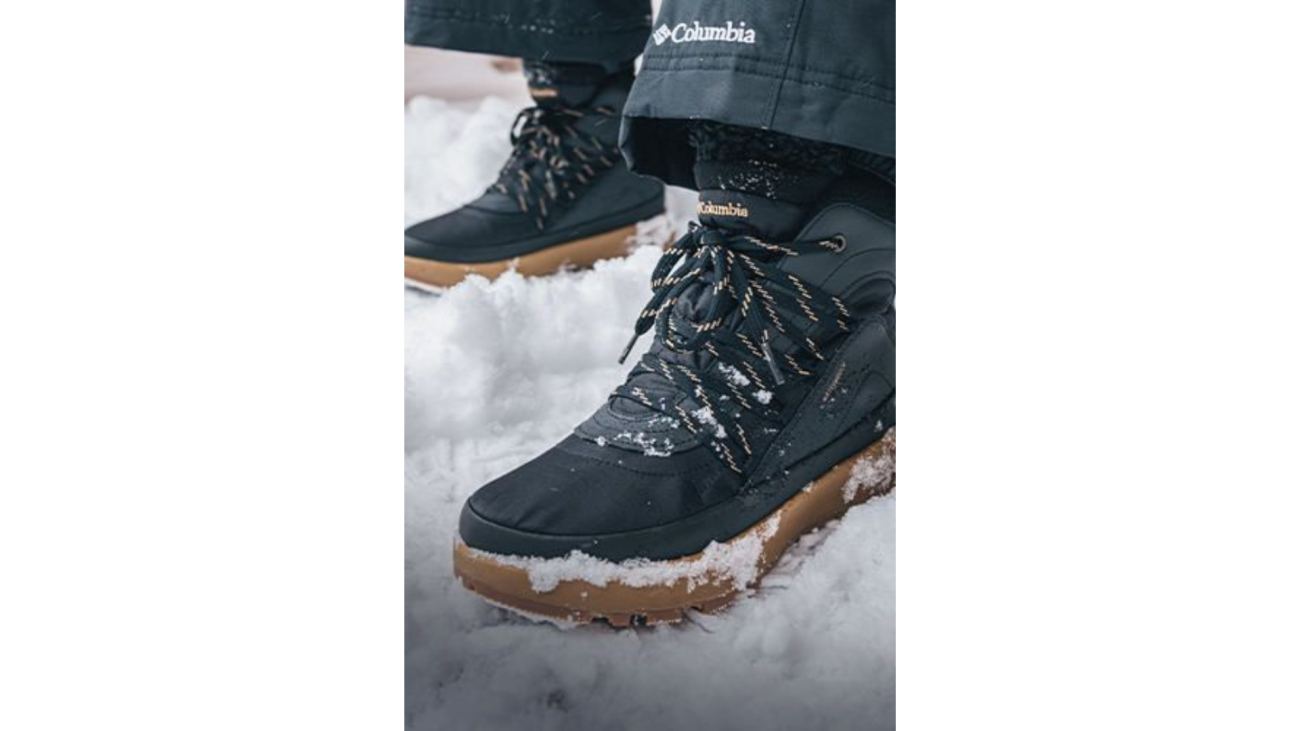รองเท้ากันหนาว Columbia สีเข้ม ถ่ายใกล้บริเวณหิมะเกาะพื้นรองเท้า