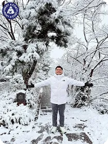 รีวิวลูกค้าผู้ชายใส่แจ็คเก็ตกันหนาวสีขาว ถ่ายรูปในสวนหิมะ