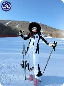 รีวิวเช่าชุดสกีสีขาว ลูกค้าถือสกีถ่ายรูปบนภูเขาหิมะ